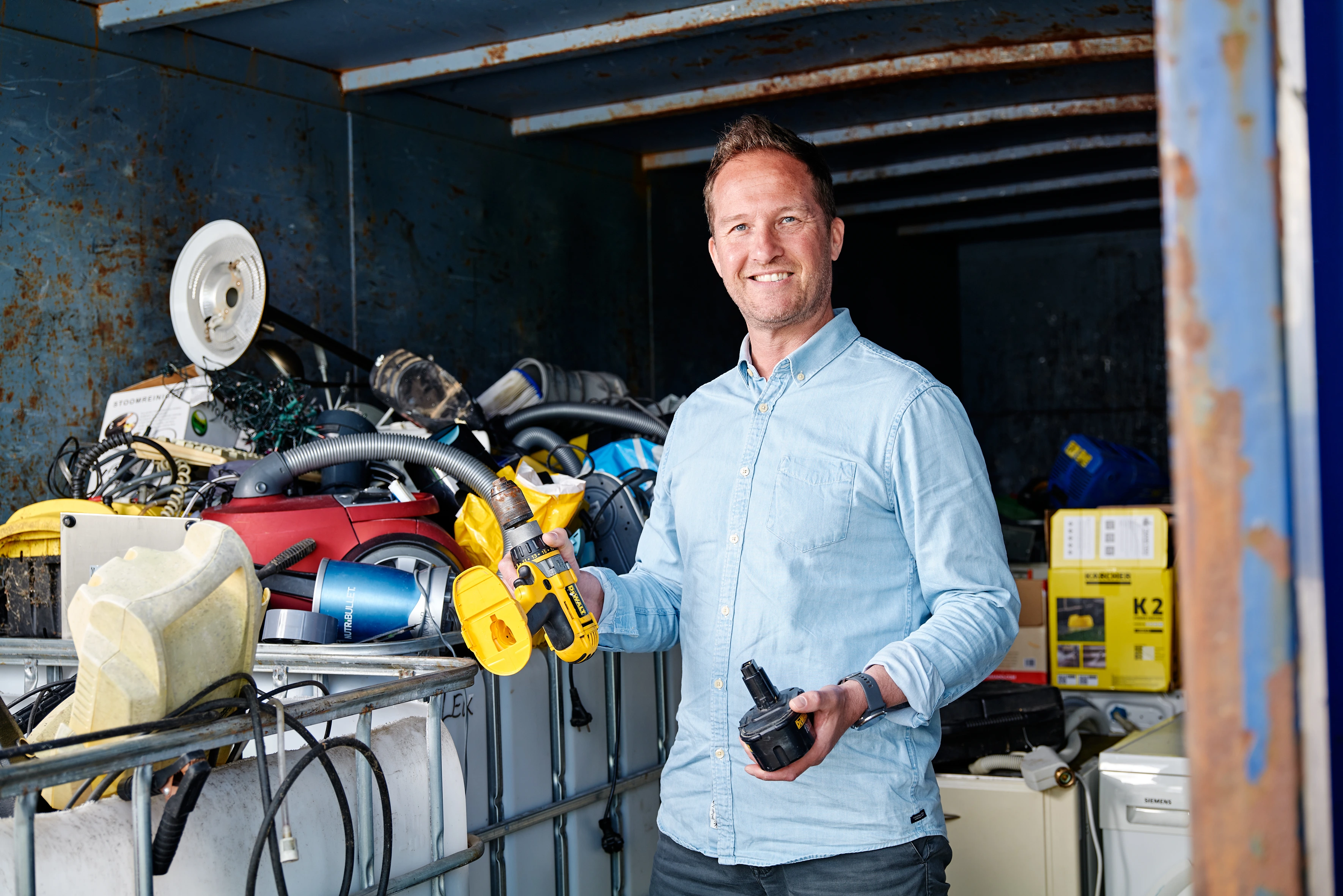 A man carrying an electronic device to recycle