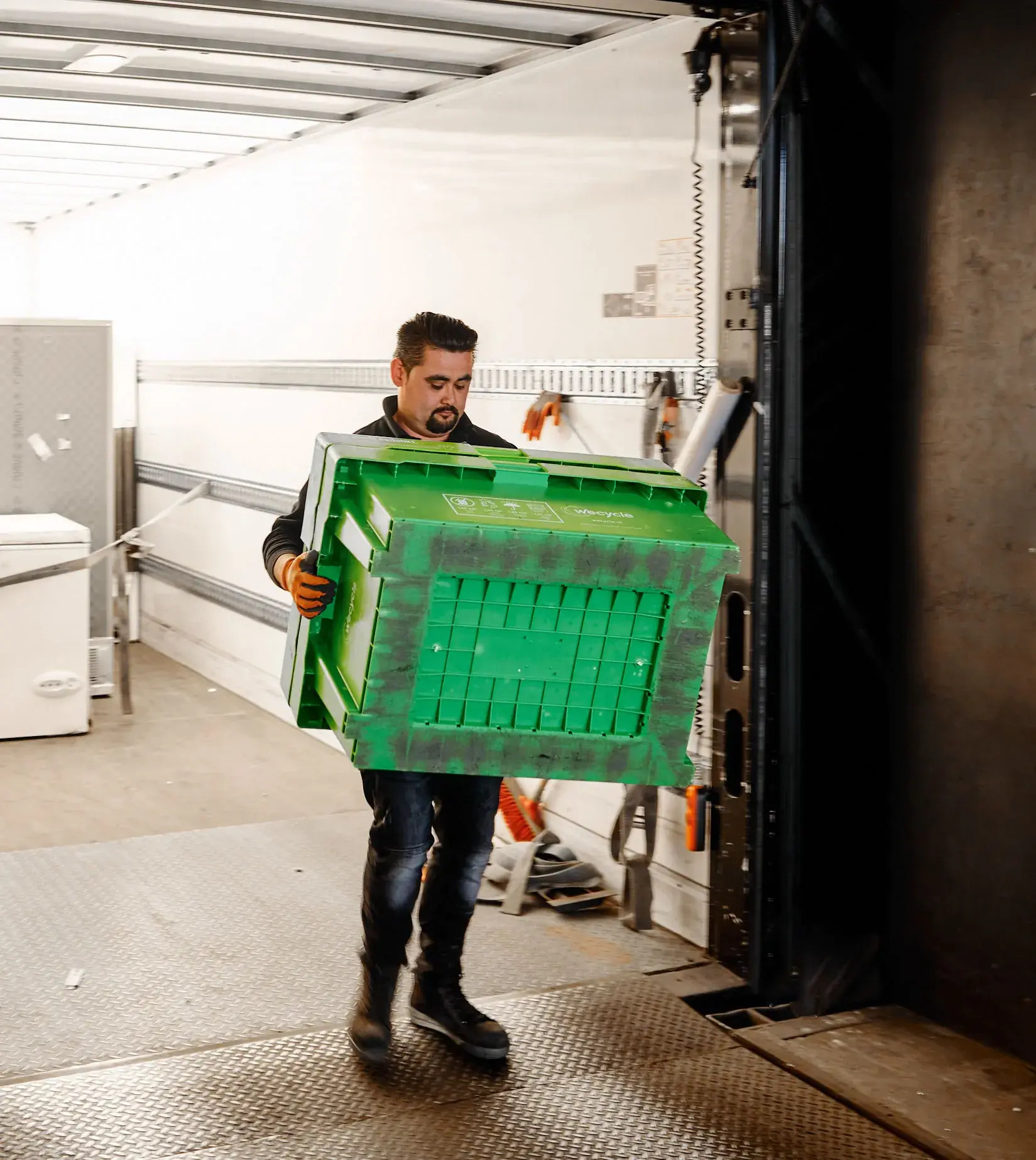 A man carrying a box with electronics to recycle